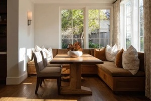 sun-drenched, cozy breakfast nook features a custom built-in banquette with plush seating