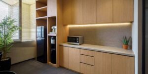 modern office pantry with wooden cabinets, microwave, and water dispenser