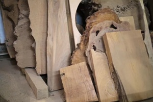 rough-cut wood slabs lean in a workshop, natural patterns highlighted